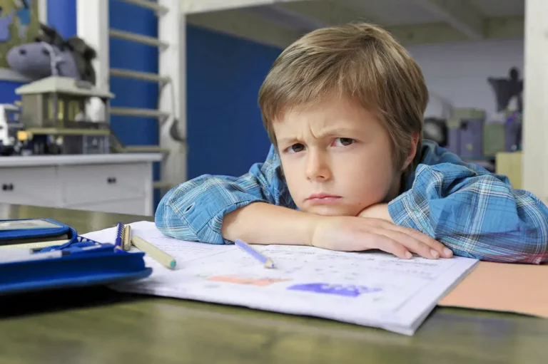 Junge schaut unglücklich über die Hausaufgaben